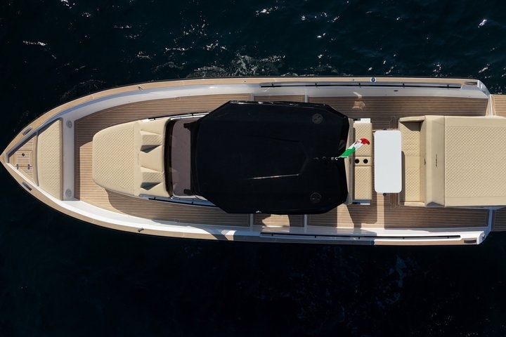Aerial view of a sleek motorboat with a dark covering on the deck.
