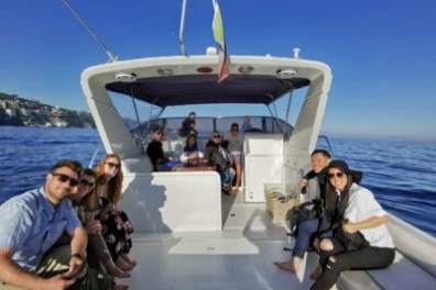 Group of people relaxing on a boat at sea under clear blue skies.